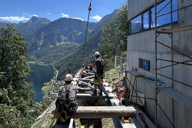 Salzwelten Hallstatt Umbau Salzbergbahn Schienenteil gebogen Montage letztes Stück Personen Warnweste & Helm  | © Salzwelten