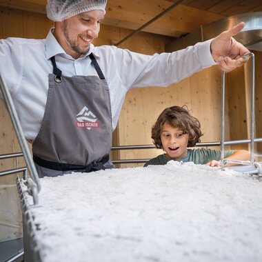 Junge mit Pfannmeister in der Salzmanufaktur | © Bergauer Schaumanufaktur Salzproduktion hautnah | © Bergauer