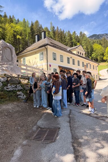Salzwelten Altaussee Barbaradenkmal neues Denkmal im Hintergrund vorbei Schüler*innen  | © ©Salzwelten Grögler